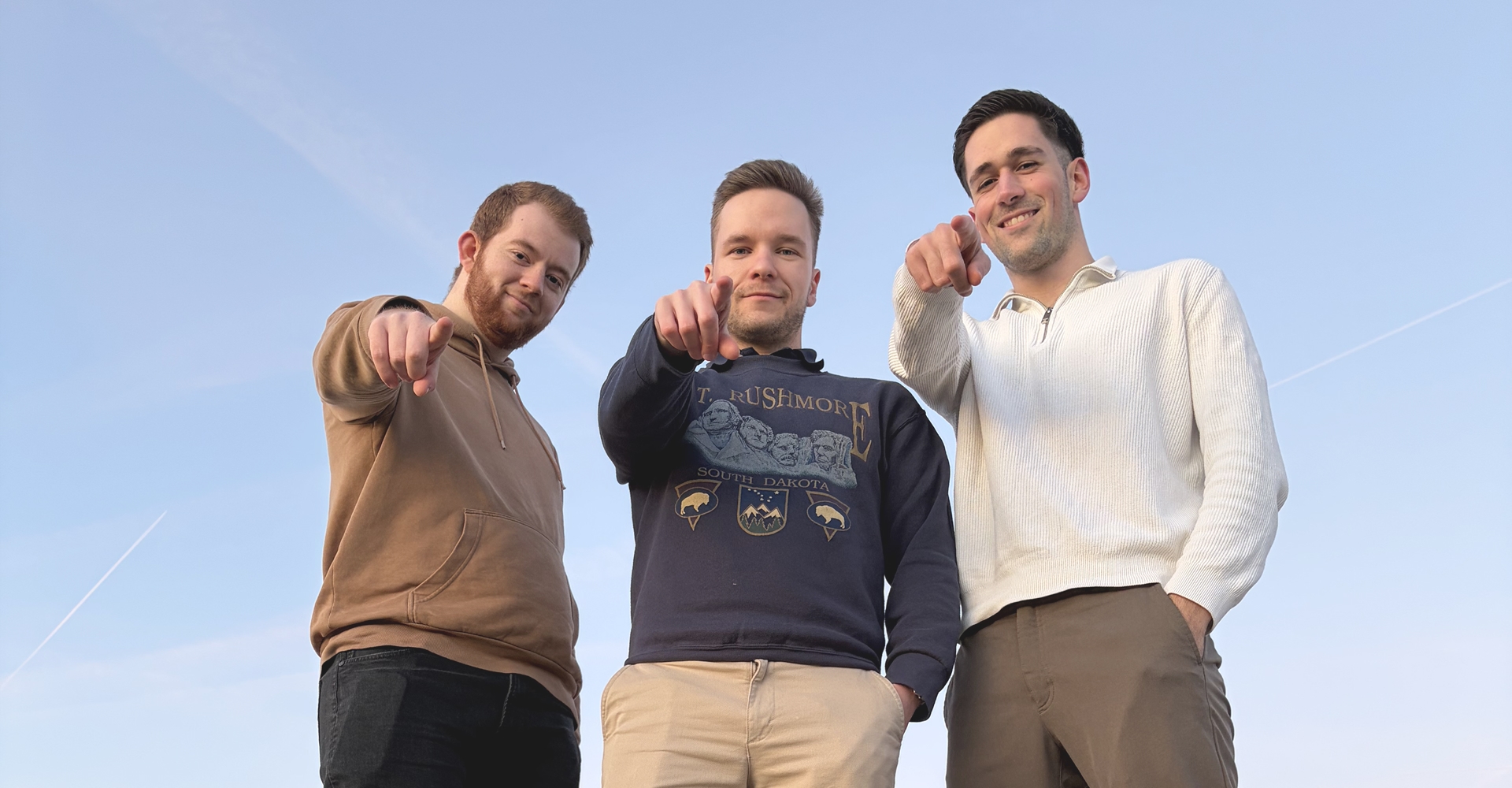 Teambild von den drei Gründern die in die Kamera zeigen